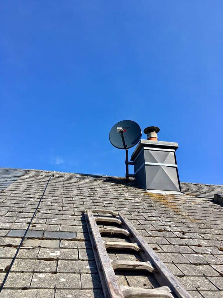 Satellite dish beside a chimney