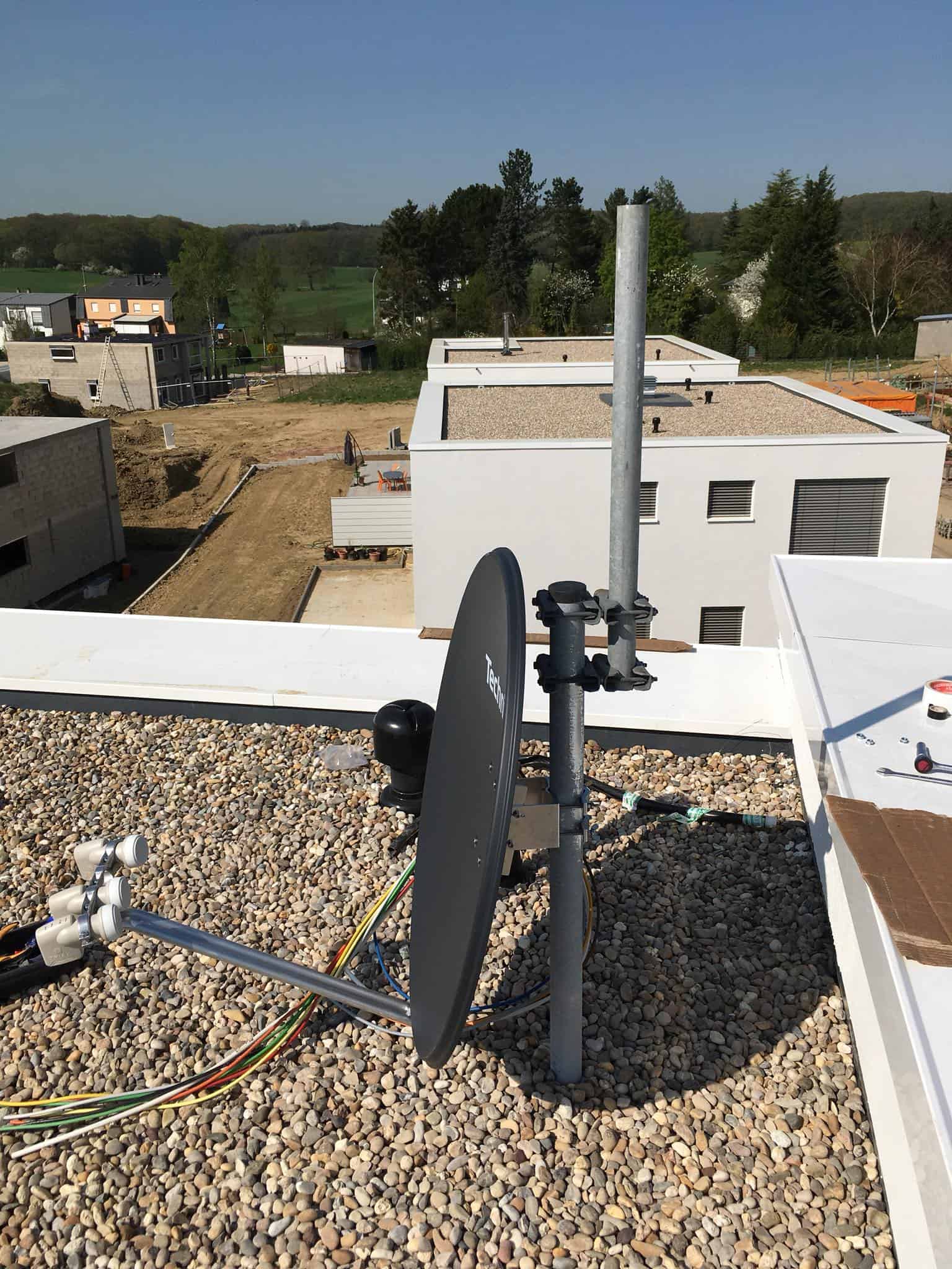 Satellite dish installation on a rooftop mast
